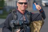 skydiving videographer and photographer, Craig O'Brien gives a thumbs up before boarding a skydiving plane.