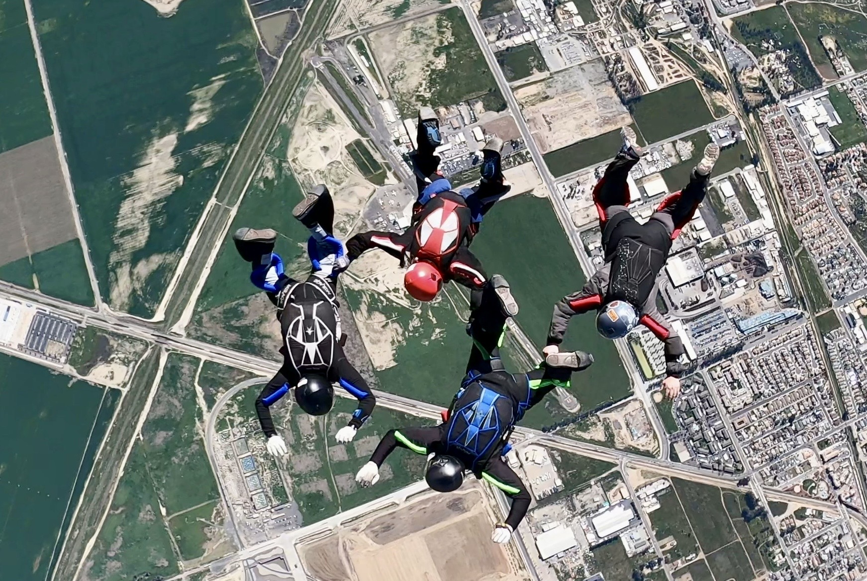 4 way formation skydivers in freefall belly formation