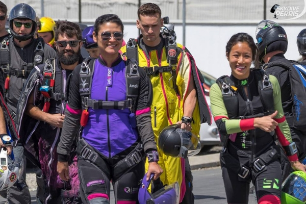 Angie Aragon walking with other fun jumpers in purple jumpsuit