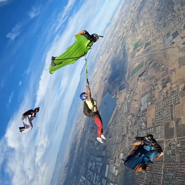 skydiver hangs off of wingsuit in freefall