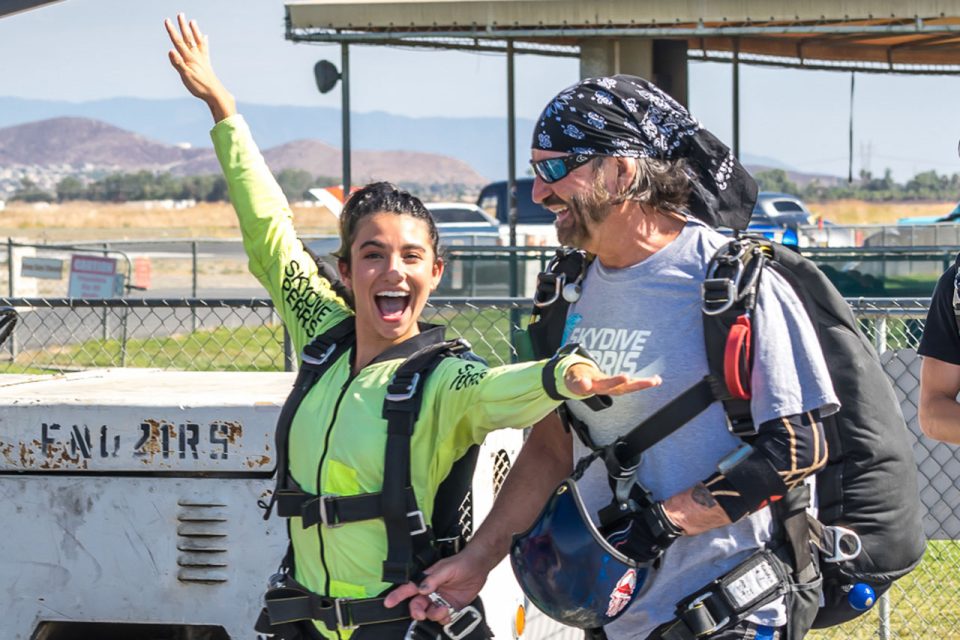 A Tandem student smiles and laughs while walking to the plane.