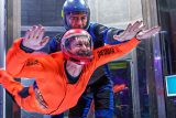 Instructor and student flying in indoor skydiving tunnel