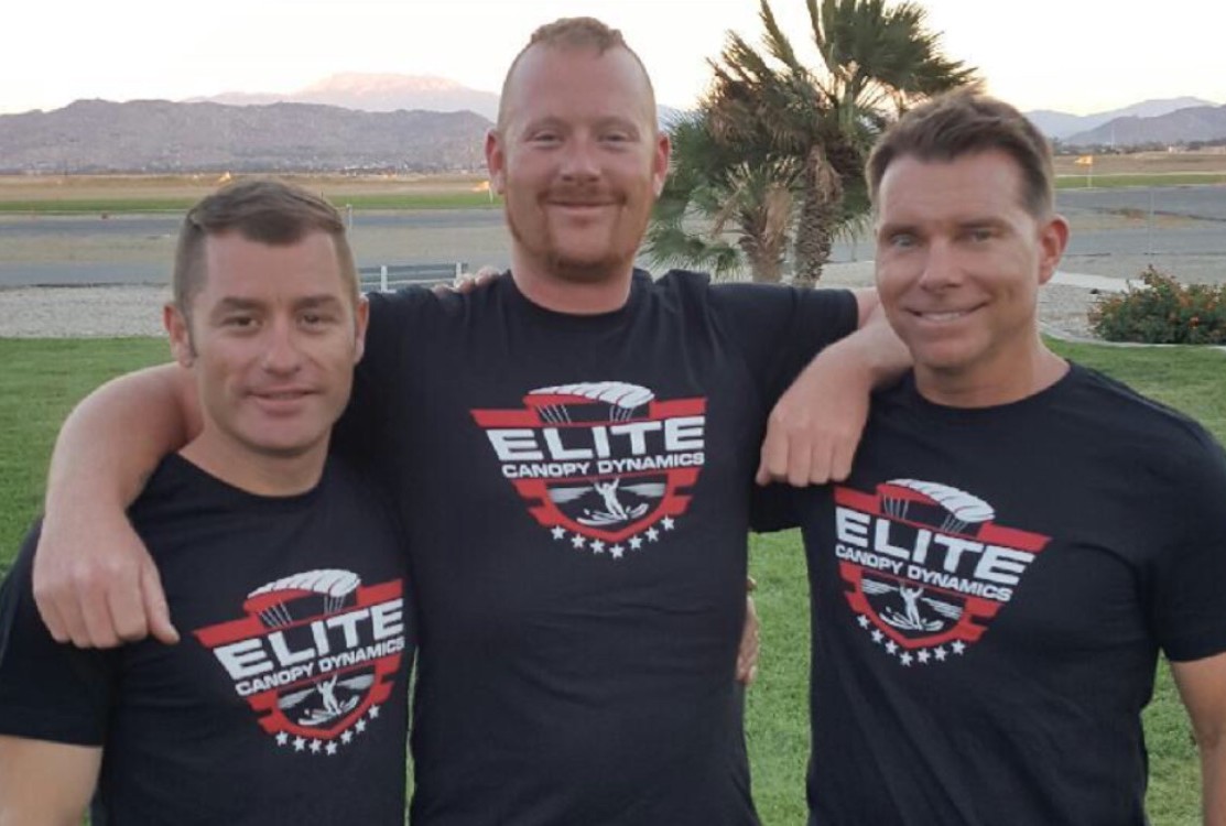 Josh Colby wraps his arms around his friends while smiling.