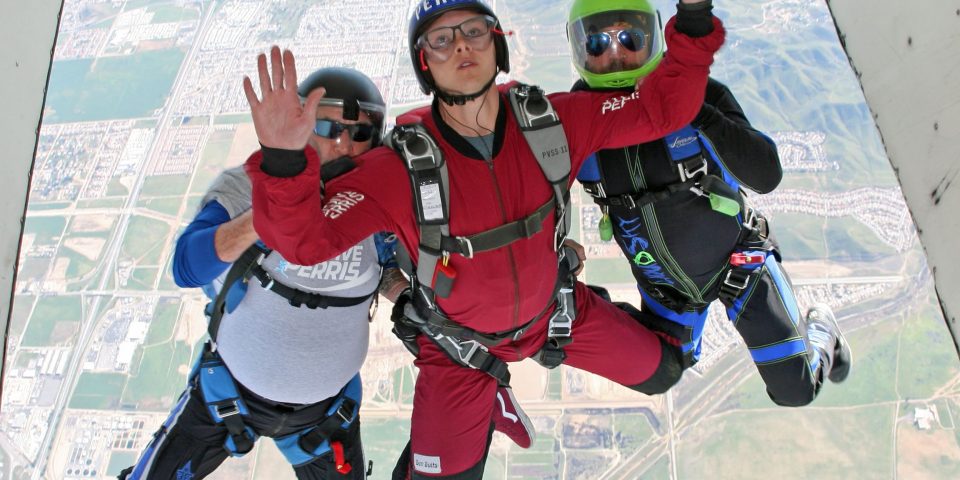 solo skydiving student exits aircraft with PSP AFF instructors at Skydive Perris learning to skydive solo near San Diego