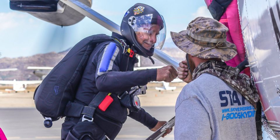 skydivers fist bumping while loading airplane