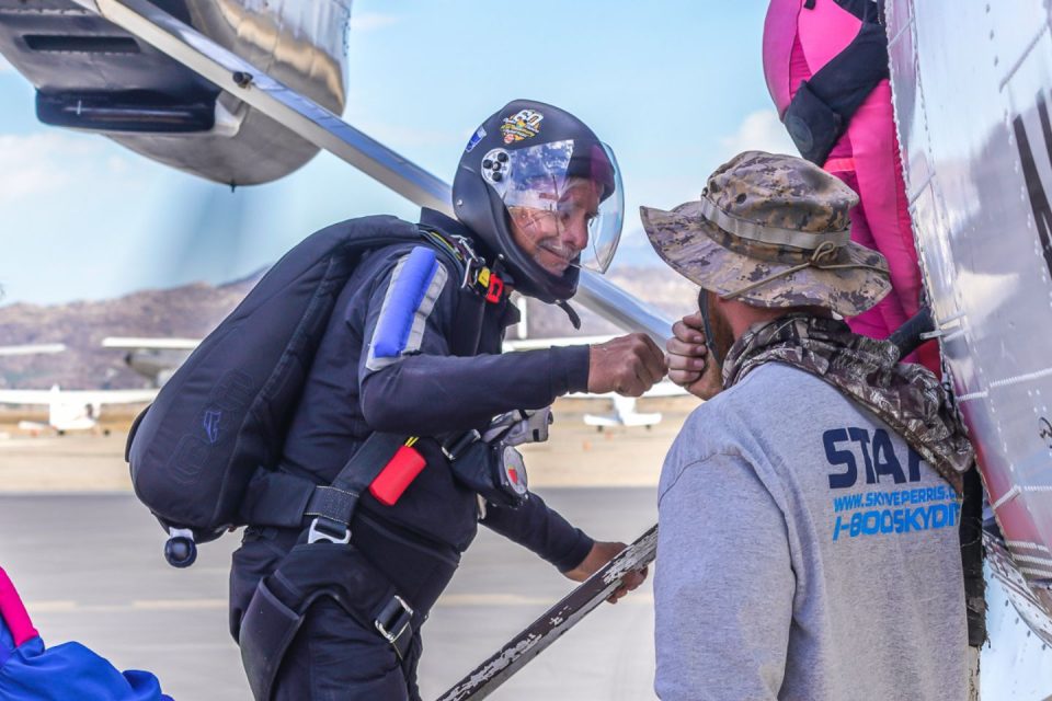 skydivers fist bumping while loading airplane