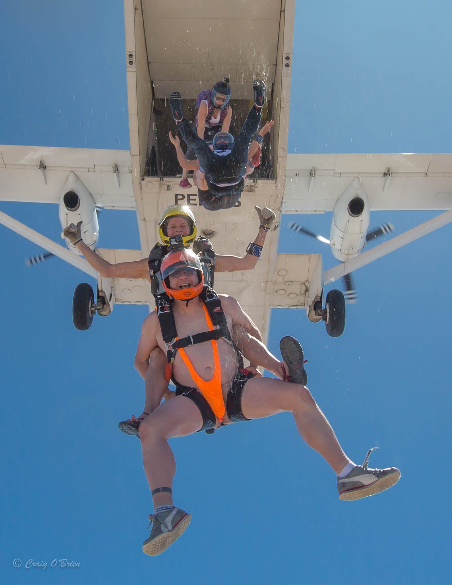 tailgate skydiving exit man in orange G string bathing suit