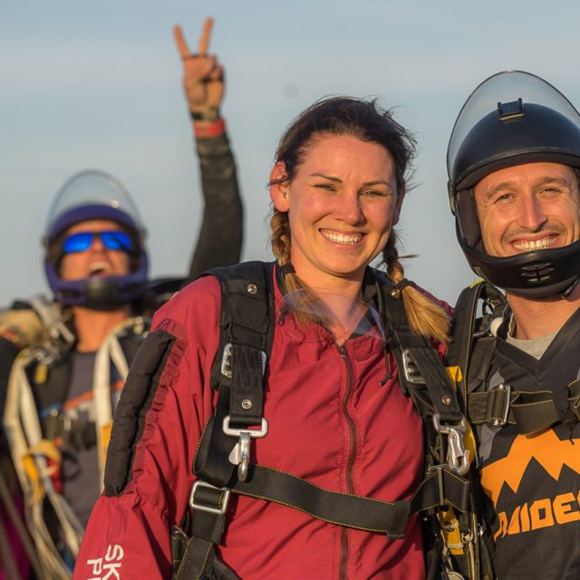 tandem skydiver and instructor smile after landing from a skydive