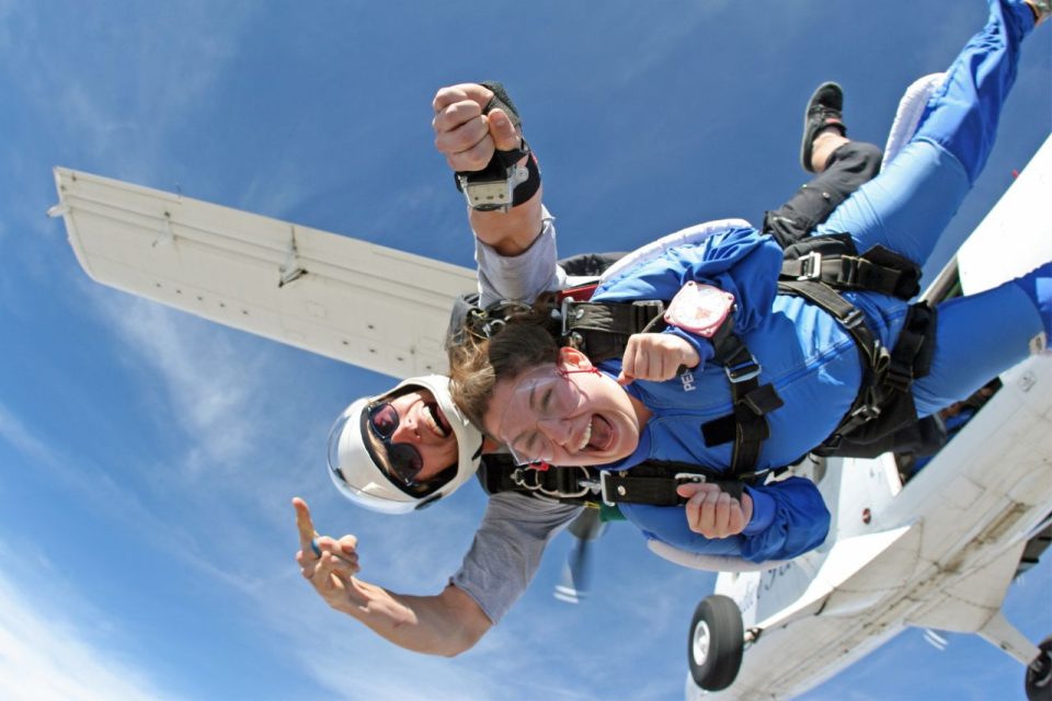 Tandem skydivers exiting airplane