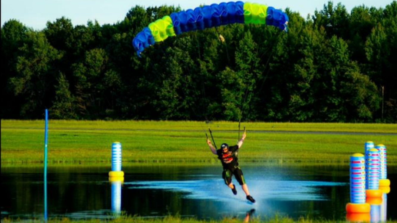 Josh Colby swoops across the pond under his blue and lime green canopy.